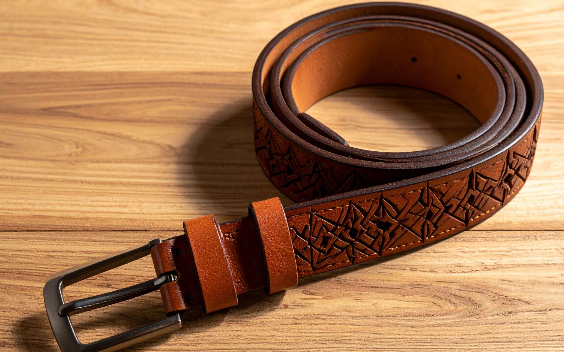 CO2 laserskærer graverer præcist i naturbrunt læderbælte med skarpe detaljer