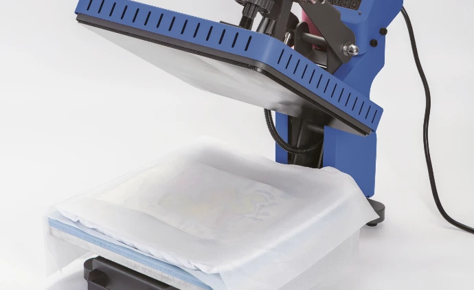 Hænder trykker håndtaget ned på varmepresse 38×38 cm med T-shirt under den varme plade
