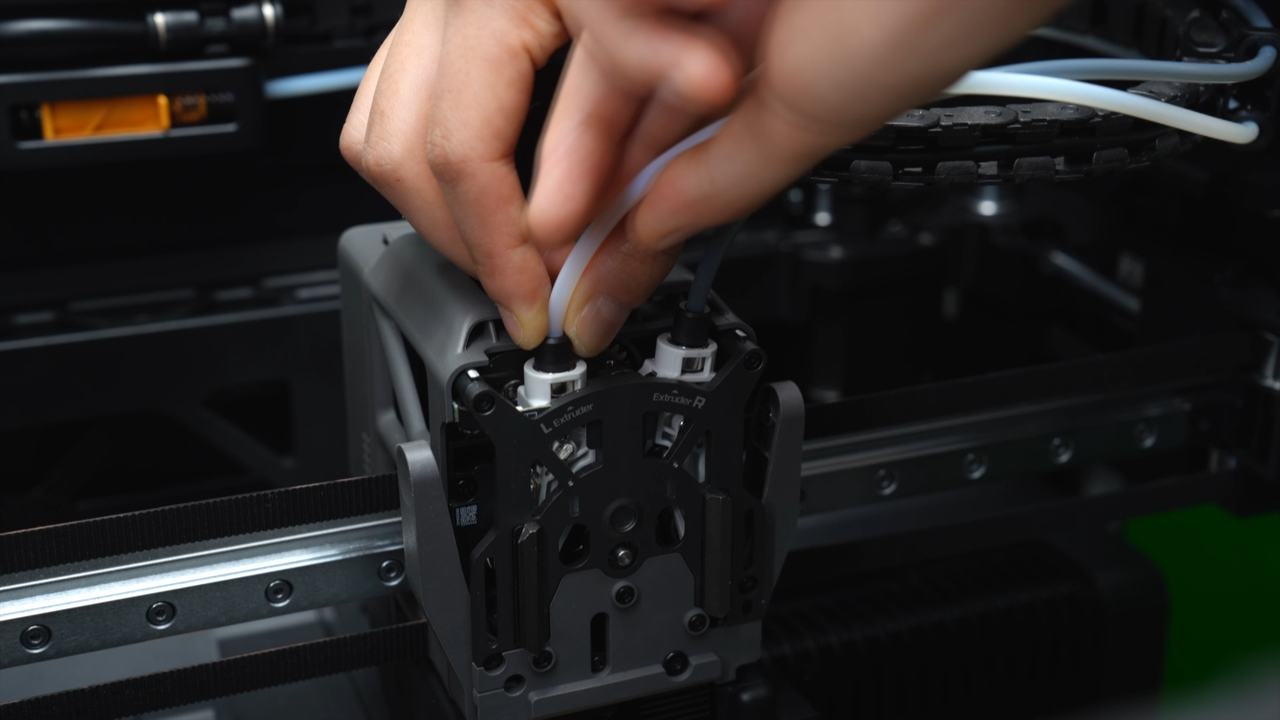 De to PTFE-koblinger over extruderen låses op