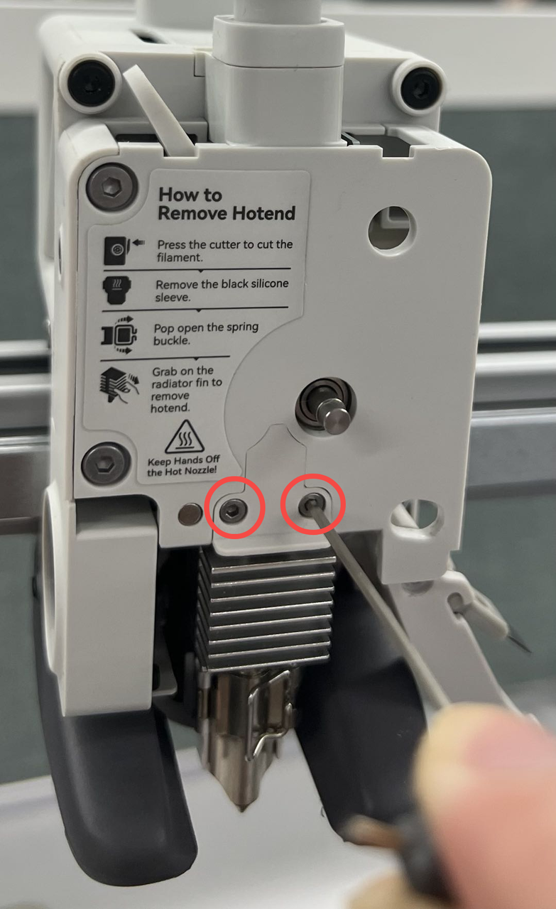 Skru de to skruer ud på trykblokken