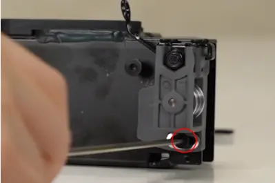 Antirotationstappen fjernes med strammeskrue F