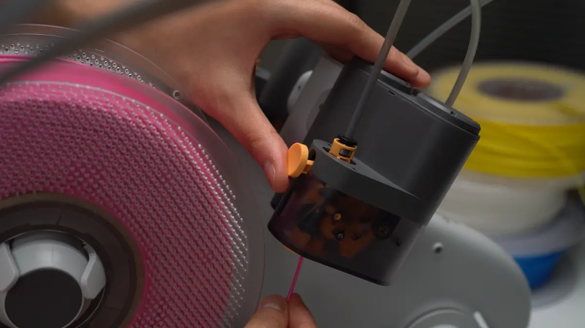 Filament føres ind i indføringsåbningen på AMS Lite