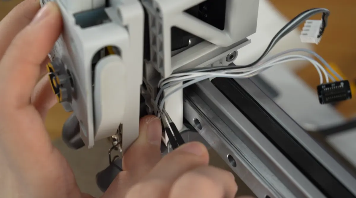 Kablet skubbes ind i clipsen med en pincet