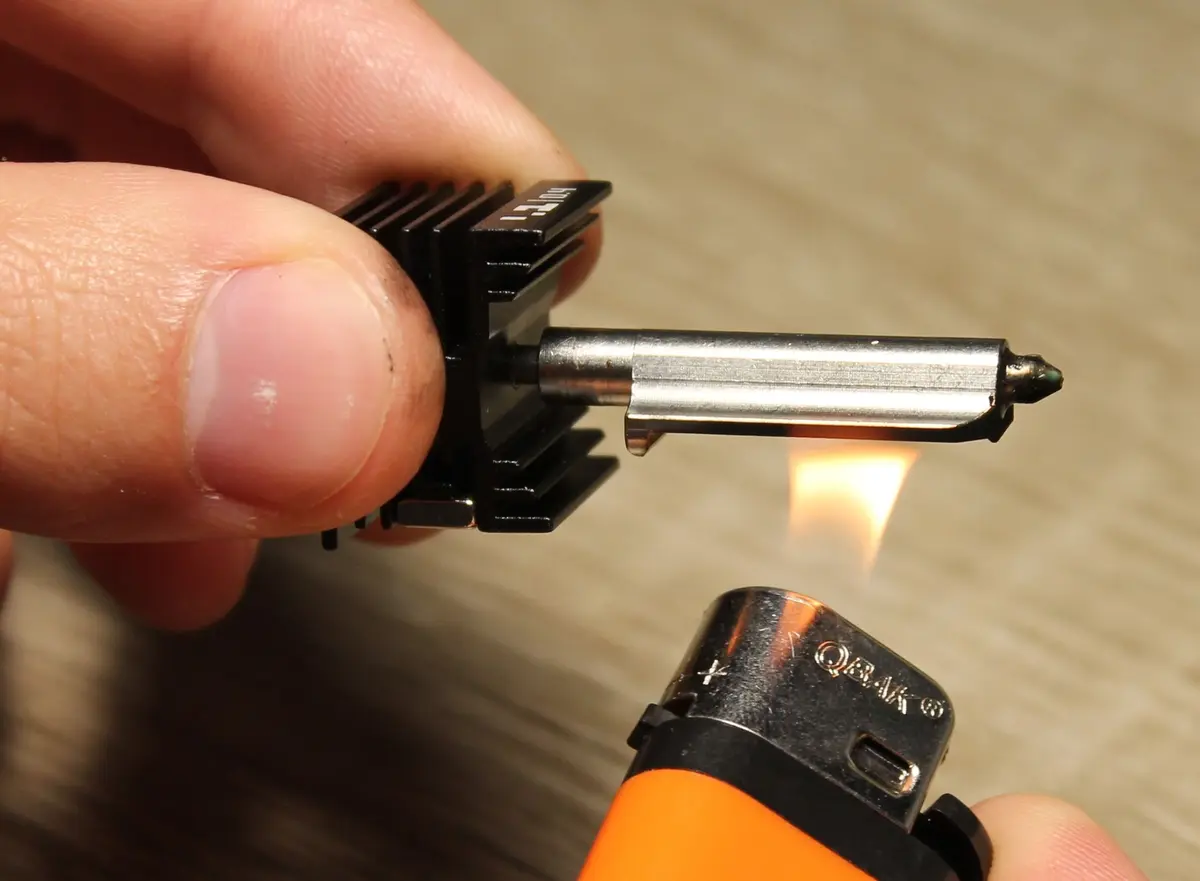 Opvarmning af dysespidsen med lighter efter fjernelse af silikonesok