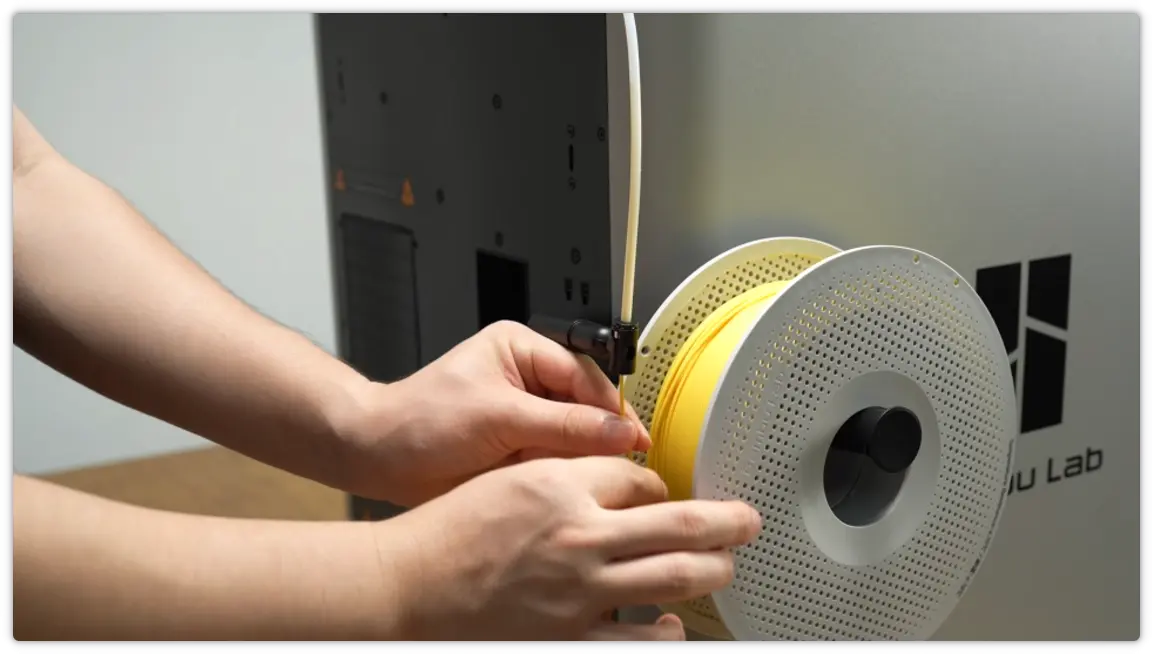En spole filament lægges på spoleholderen og filamentet skubbes ind i PTFE-slangen