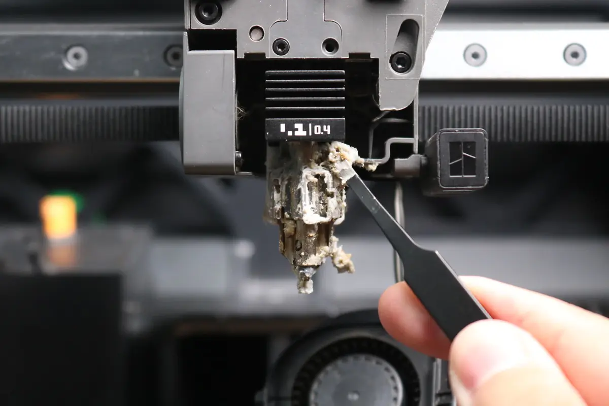 Filament omkring varmeblokken fjernes med pincet