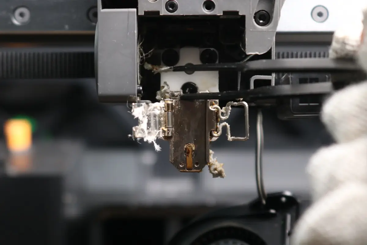Filament fjernes fra sprækker i metallet