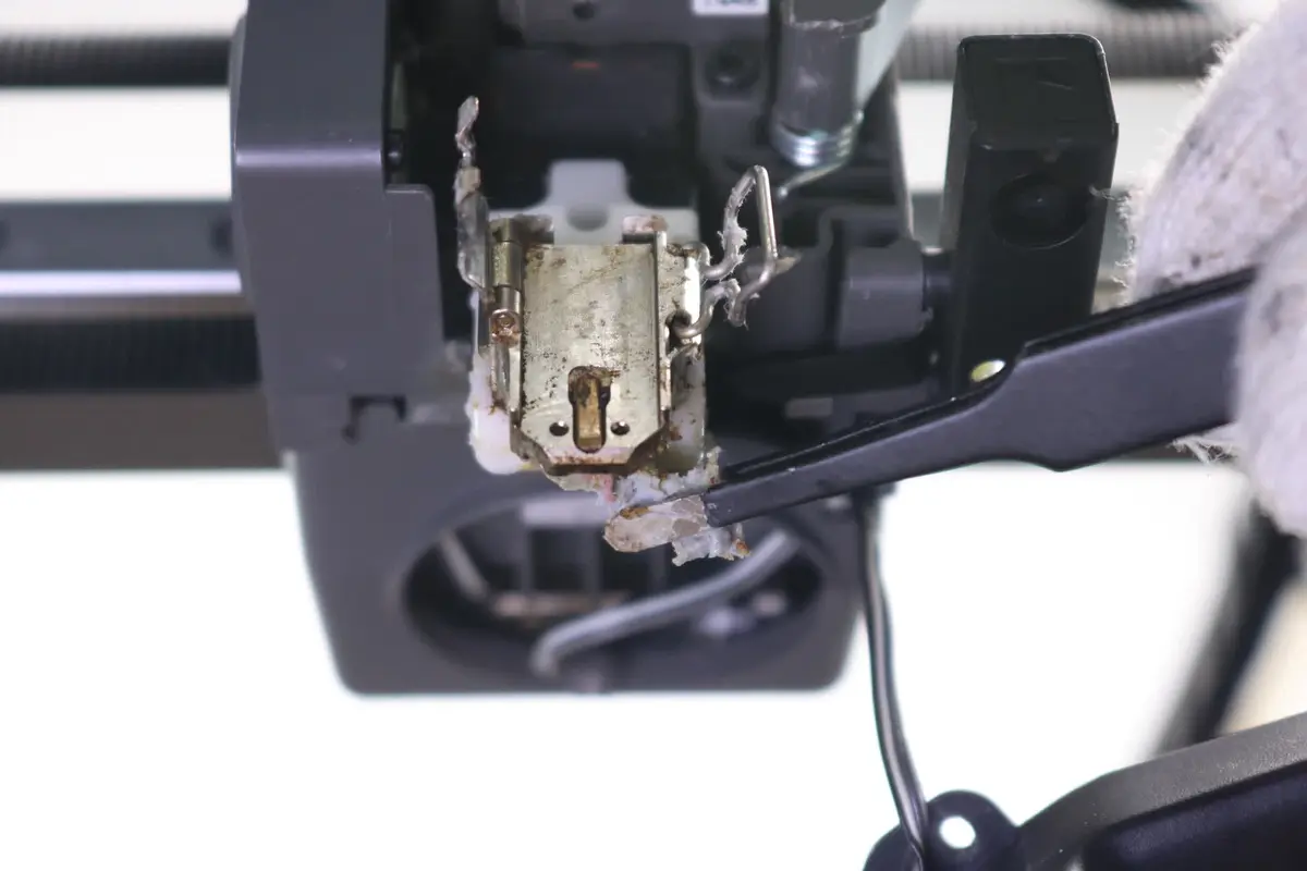 Filament fjernes forsigtigt bag varmeblokken