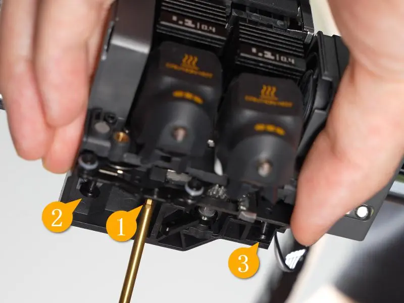 De tre skruer der holder flow blocker-enheden bag på toolhead