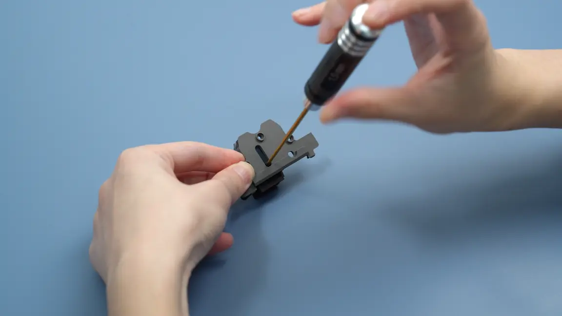Skub den sorte connector langs skinnen for at frigøre den fra det forreste føringsdæksel