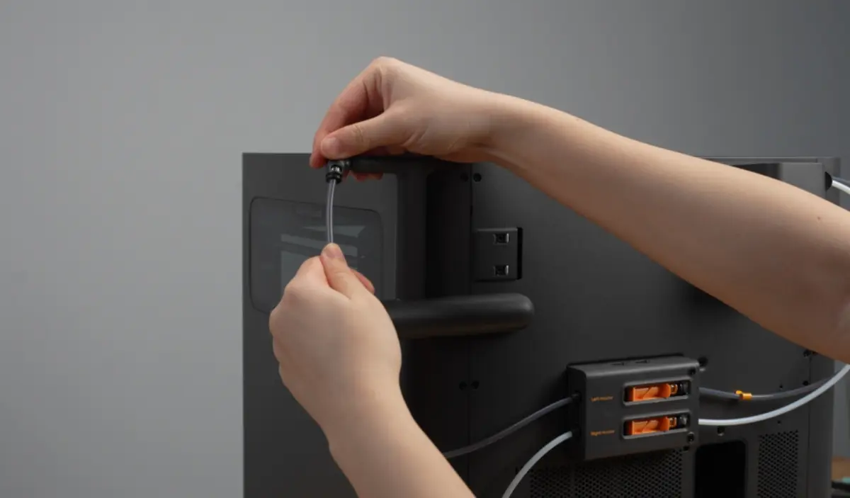 Den grå slange forbindes med den øverste spoleholder