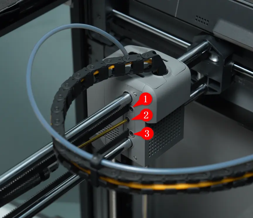 Fjern de tre M2.5x5-skruer i remfikseringsblokken og tag remmen af toolhead'et