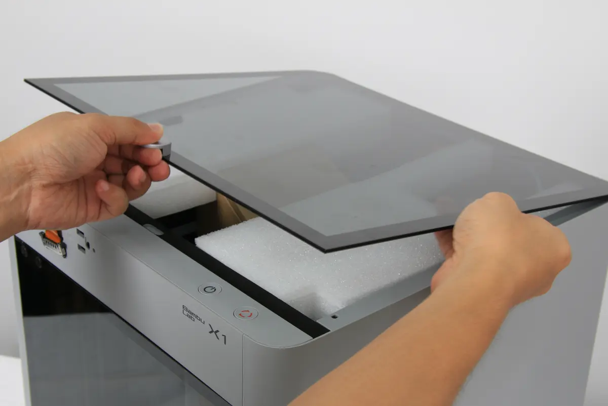 Glasdækslet løftes af printeren forsigtigt