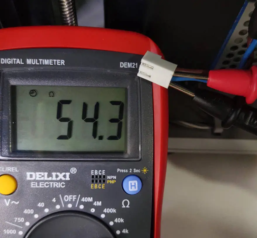 Multimeter der måler modstand på varmepladestrømkablets pins