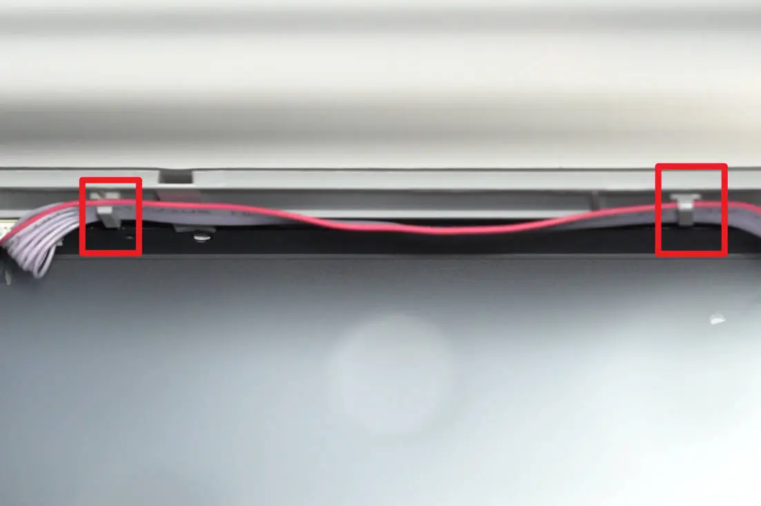 Knap-kortets kabel frigjort fra klemspænderne