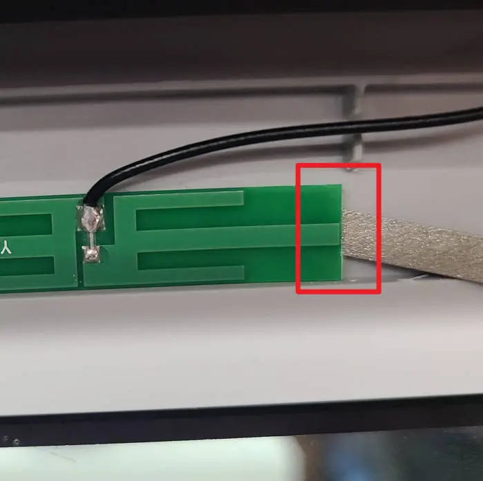 WIFI-antenne løftes forsigtigt fra frontdækslet med flade pincetter