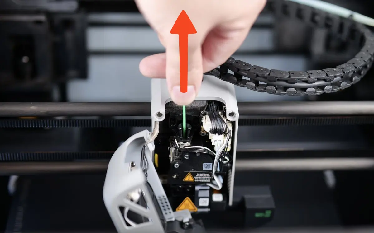 Haand der manuelt hjaelper med at trakke filament opad under cold pull-tilbagetrak