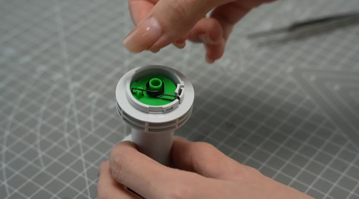 Fjederens korte side sættes på plastclipsen