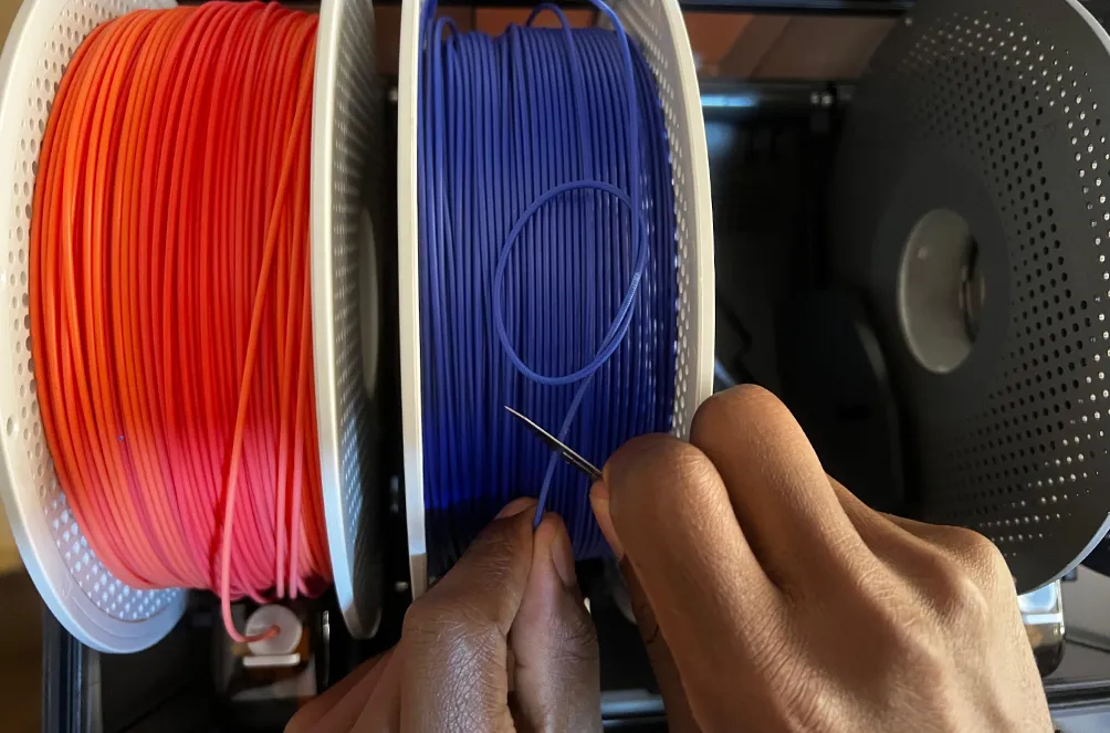 Det filtrede filament klippes over med saks
